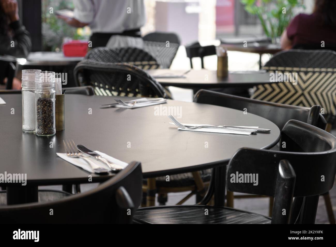 Leere Tische in einem Restaurant, die auf die Ankunft der Gäste warten, während sie für geschäftliche Zwecke geöffnet sind Stockfoto