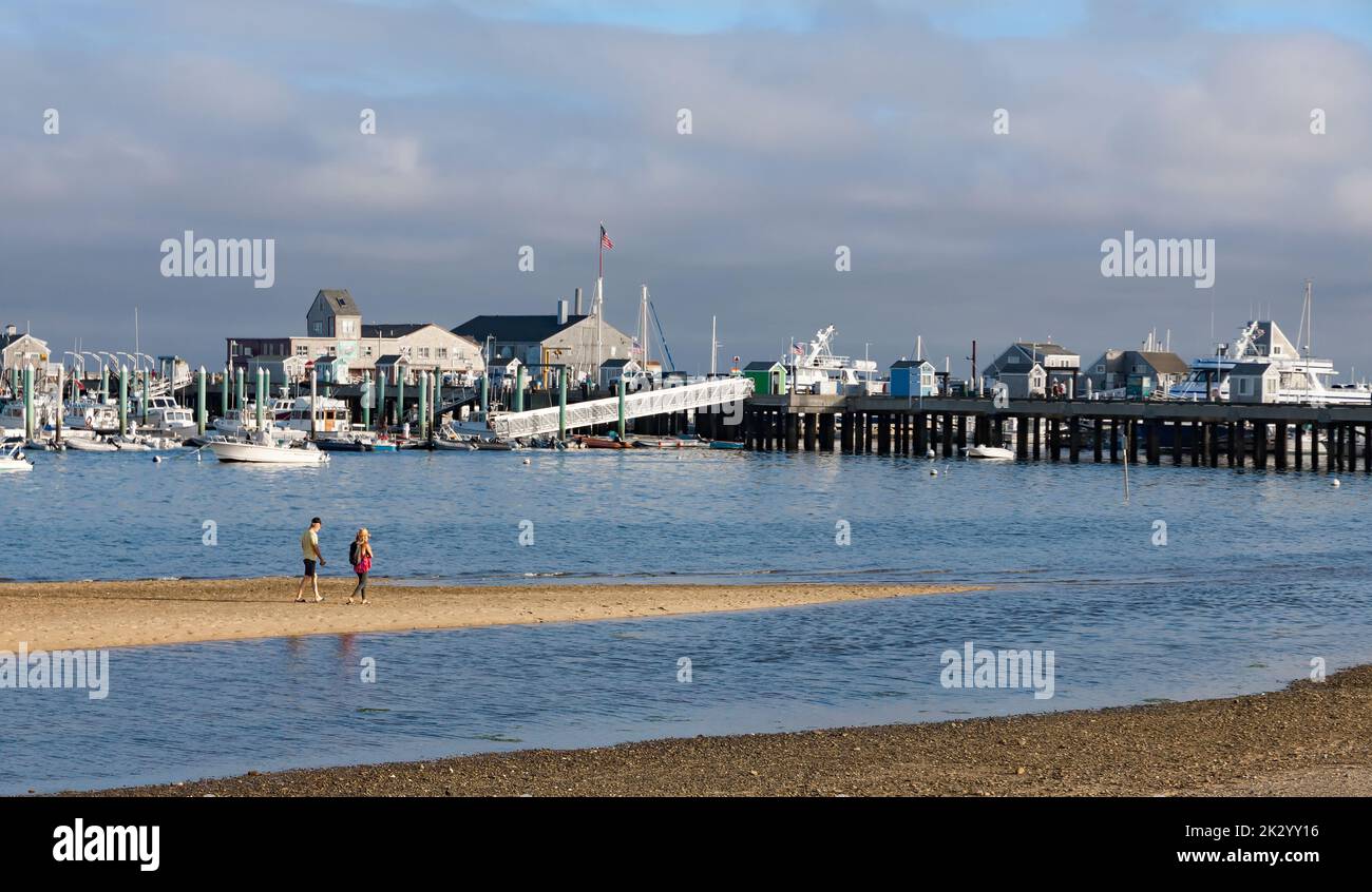 Besucher/Touristen, die MacMillan Wharf/Pier von einer Sandbar in Provincetown, Cape Cod, Massachusetts aus betrachten. Stockfoto
