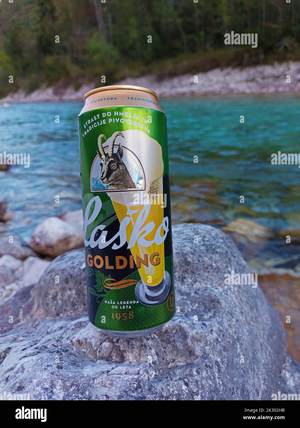 Lasko golding Bier kann am Flussufer des Flusses Soca in Slowenien getrunken werden Stockfoto
