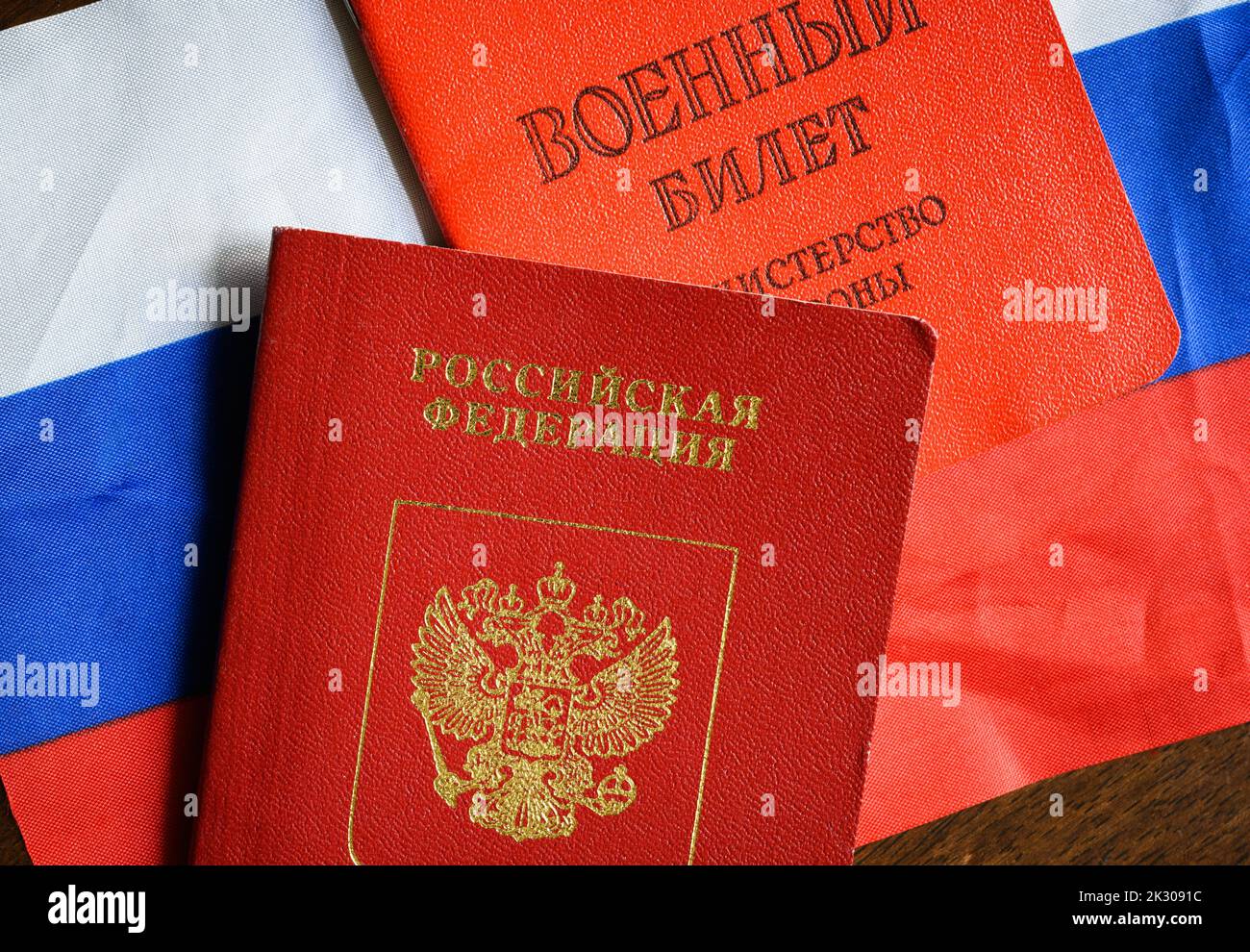 Russischer Pass, Zertifikat des russischen Militäranmannes und Flagge auf dem Tisch, Draufsicht. Konzept der Mobilisierung, Krieg in der Ukraine, Dienst, Pflicht und Armee. Trans Stockfoto