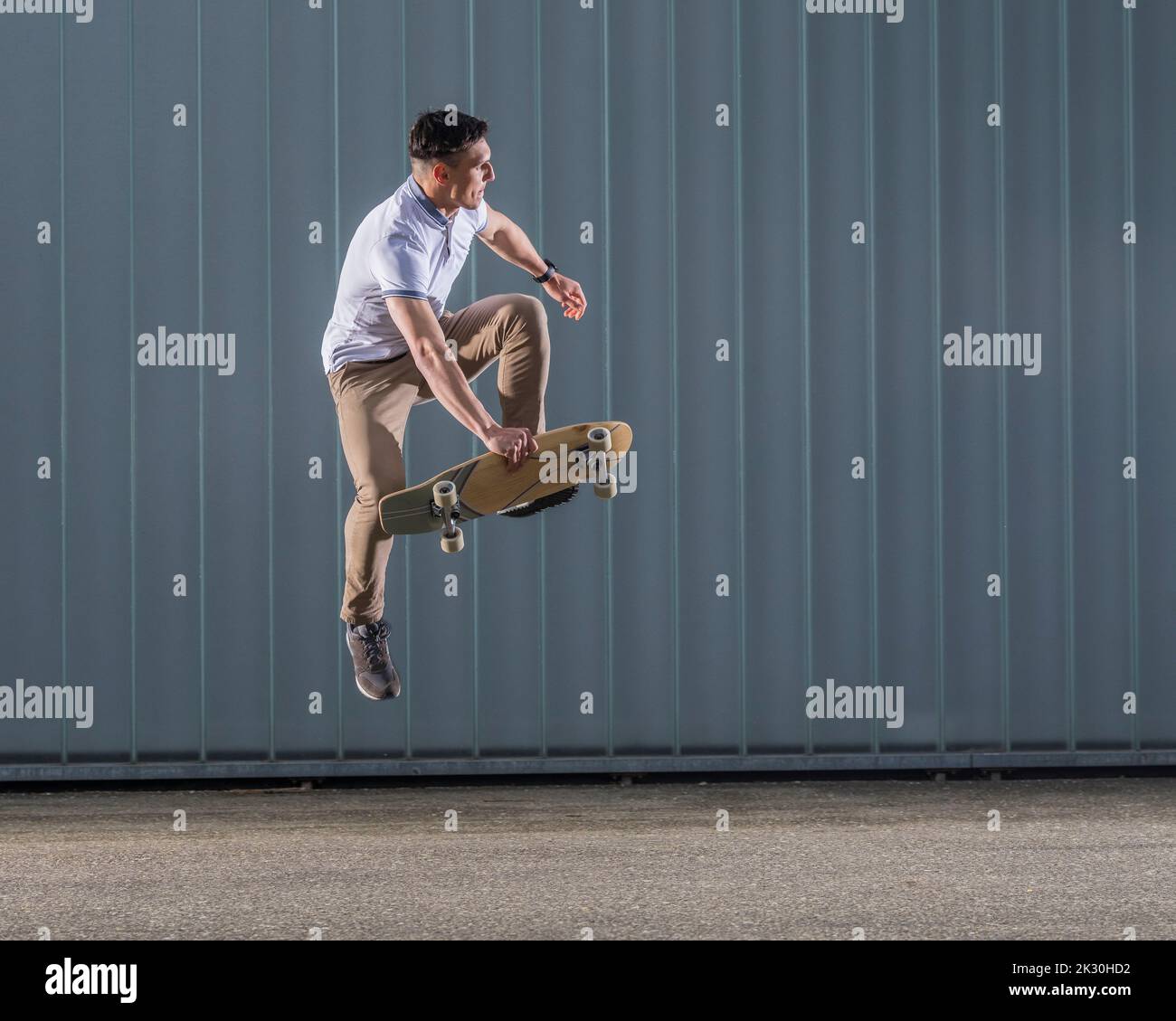 Mann übt Stunt mit Skateboard in der Luft Stockfoto