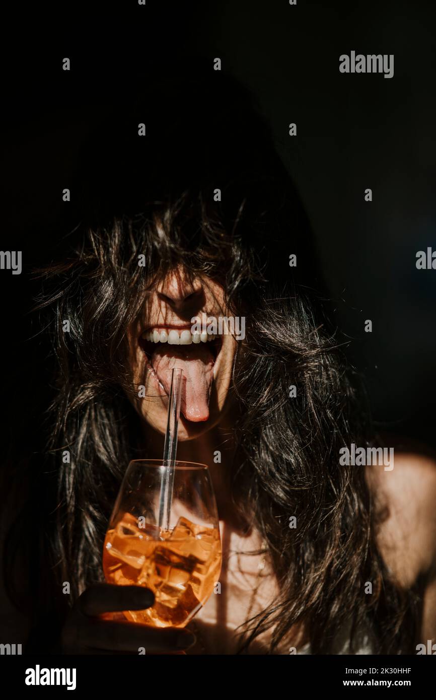 Glückliche Frau, die mit Stroh trinkt Stockfoto