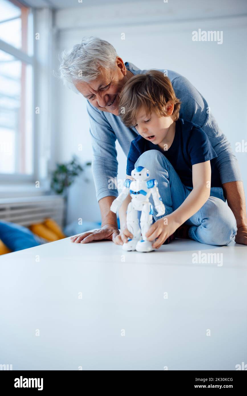 Junge mit Roboter-Modell von lächelnden Großvater zu Hause Stockfoto