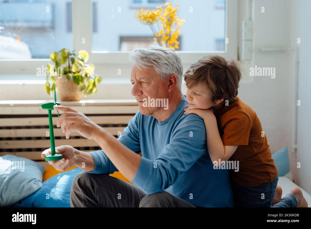 Großvater analysiert Windenergieanlagenmodell durch Enkel zu Hause Stockfoto