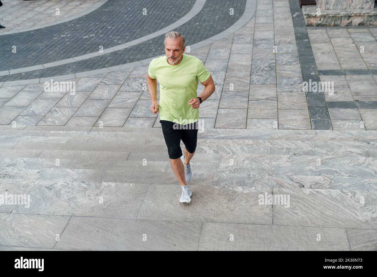 Reifer Mann, der sich auf Stufen hochbewegt Stockfoto