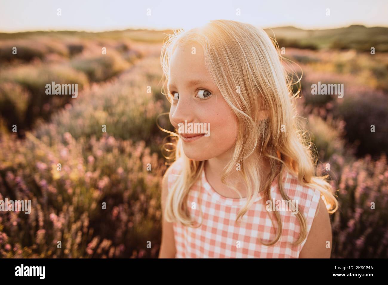Mädchen mit blonden Haaren macht Gesichtsausdruck in Lavendel Feld bei Sonnenuntergang Stockfoto
