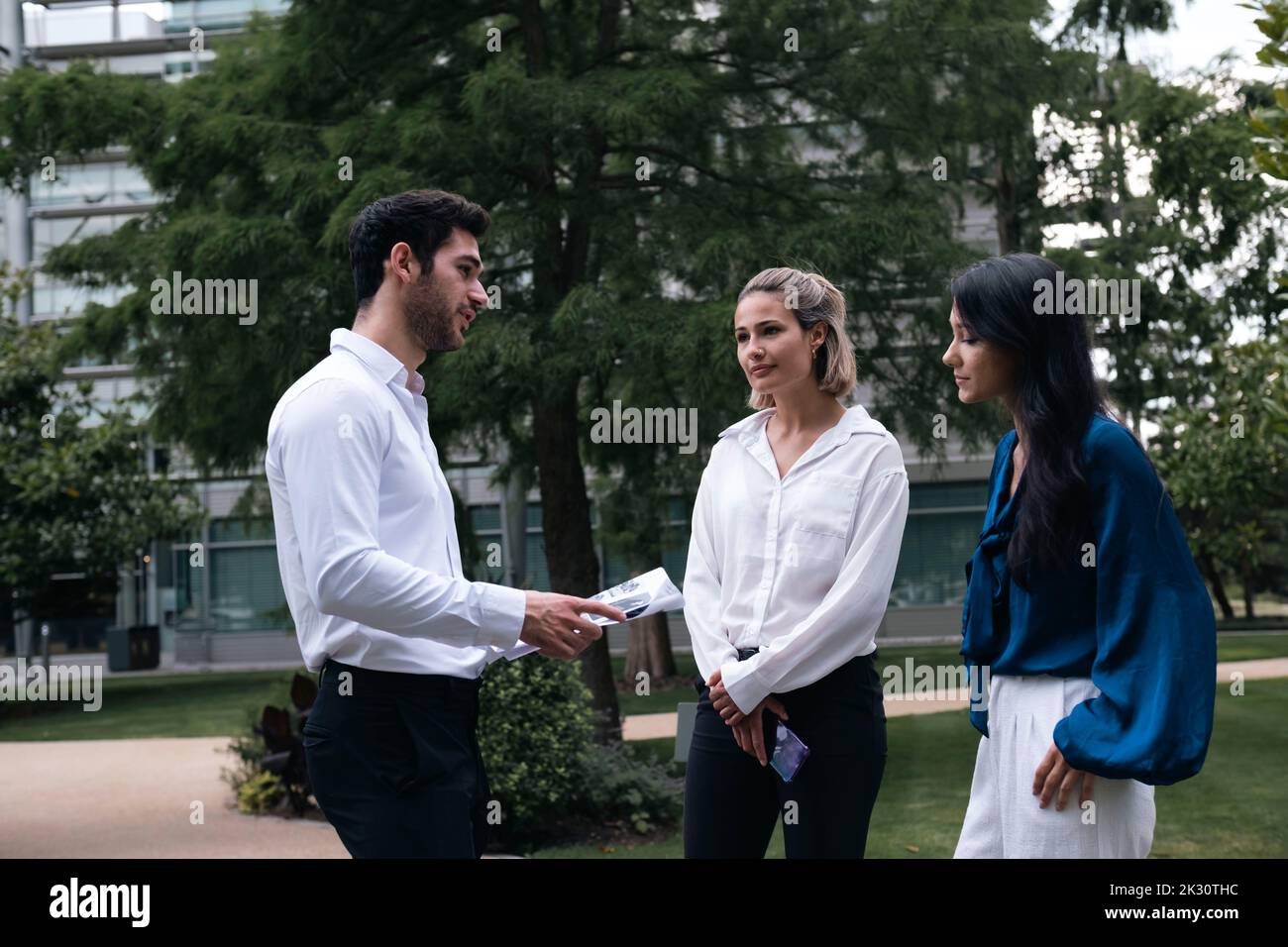 Junger Geschäftsmann, der mit Kollegen im Büropark über Dokumente diskutiert Stockfoto