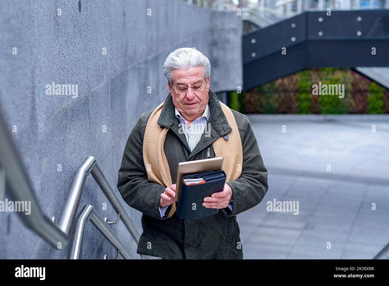 Leitender Geschäftsmann, der Tablet-PC verwendet, um Schritte zu Unternehmen Stockfoto