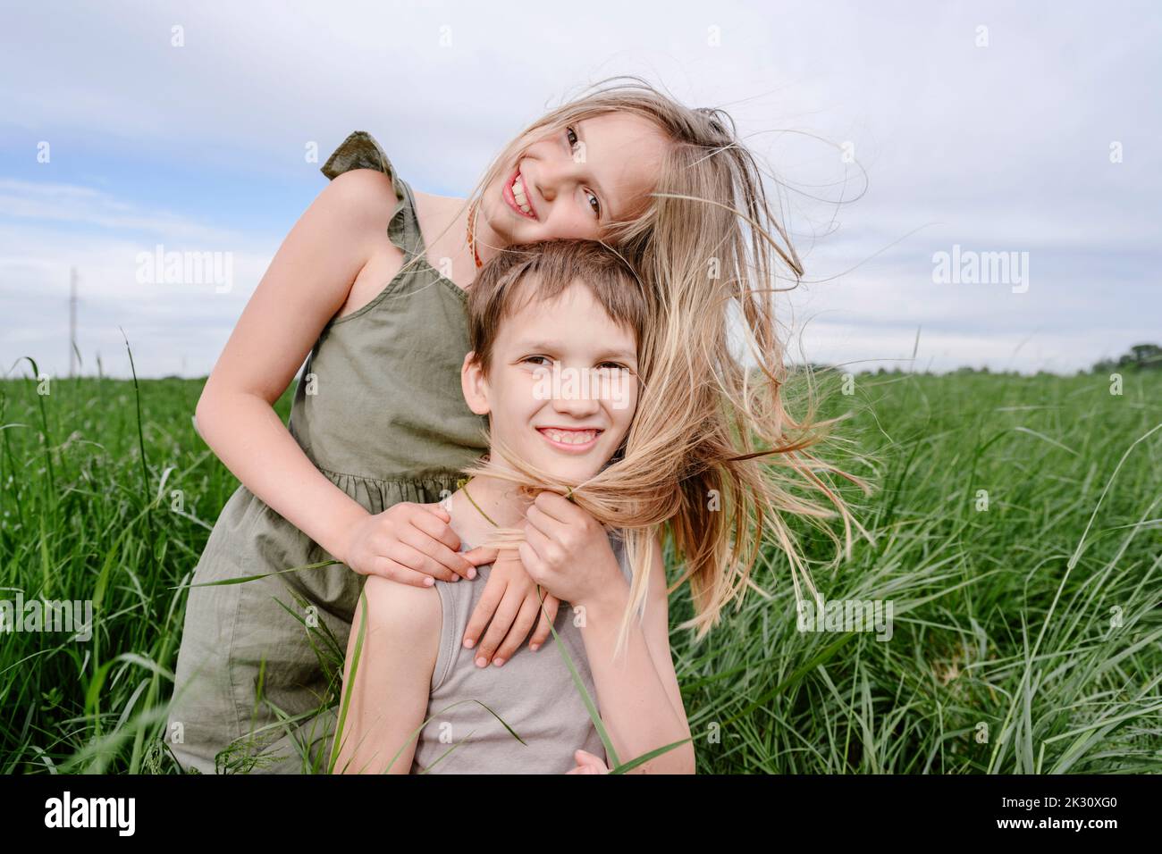 Glücklicher Bruder und Schwester zusammen auf dem Grasfeld Stockfoto