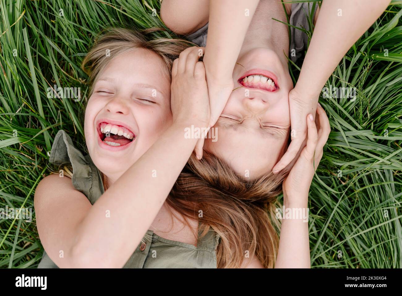 Bruder und Schwester haben Spaß zusammen auf Gras liegen Stockfoto