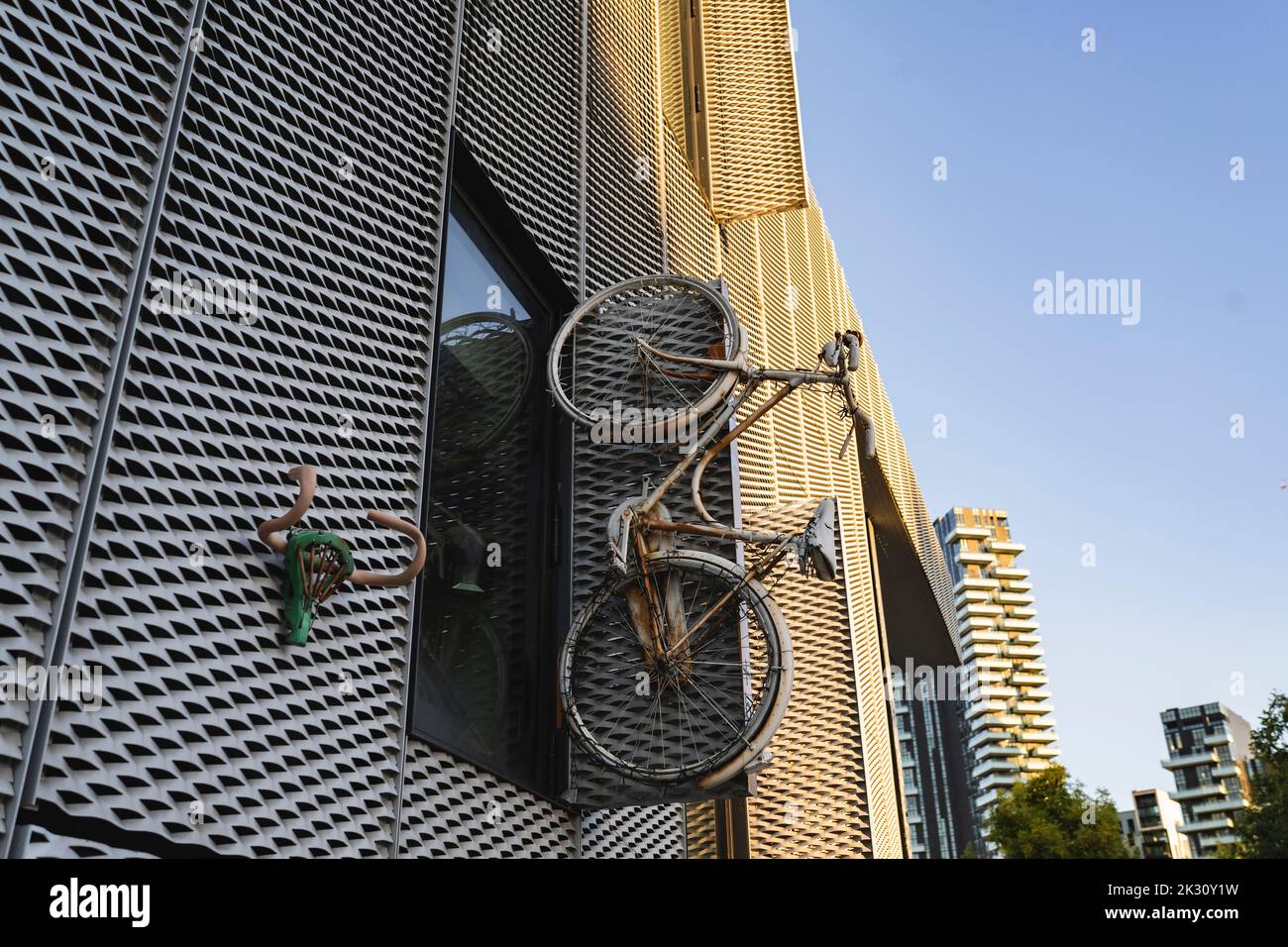 Altes Fahrrad in der Nähe des Fensters eines modernen Gebäudes montiert Stockfoto