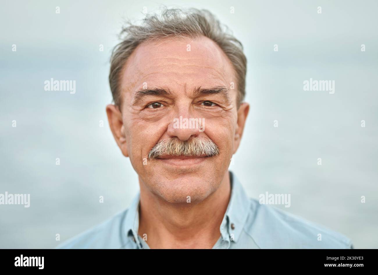 Lächelnder älterer Mann mit grauen Haaren Stockfoto