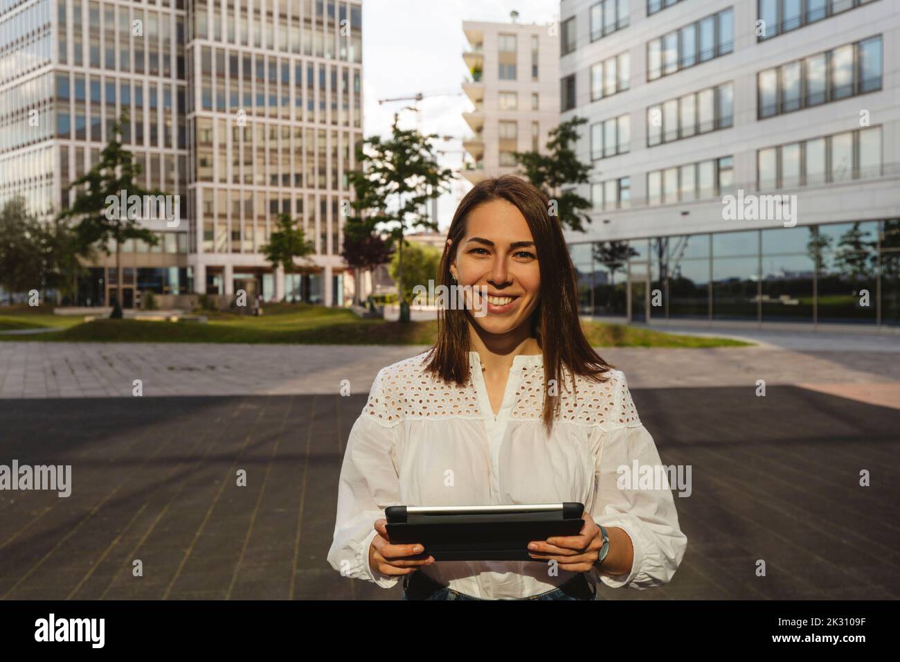 Glückliche Geschäftsfrau mit Tablet-PC im Büropark Stockfoto