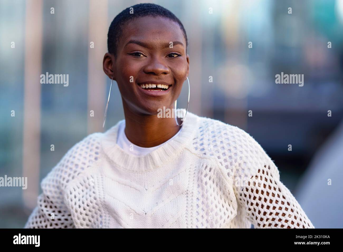 Fröhliche junge Frau mit Kreolen Stockfoto