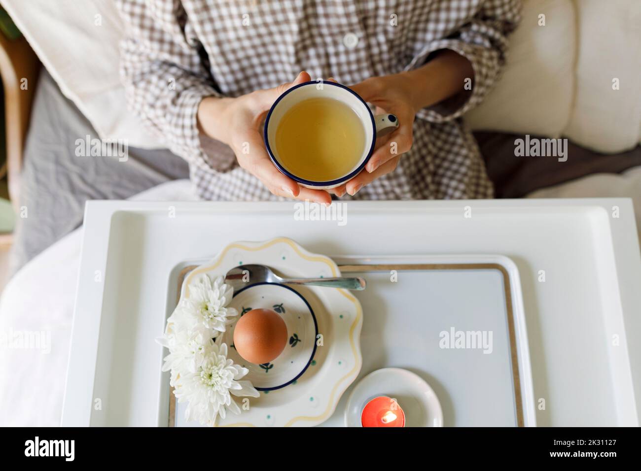 Frau beim Frühstück im Bett sitzend Stockfoto
