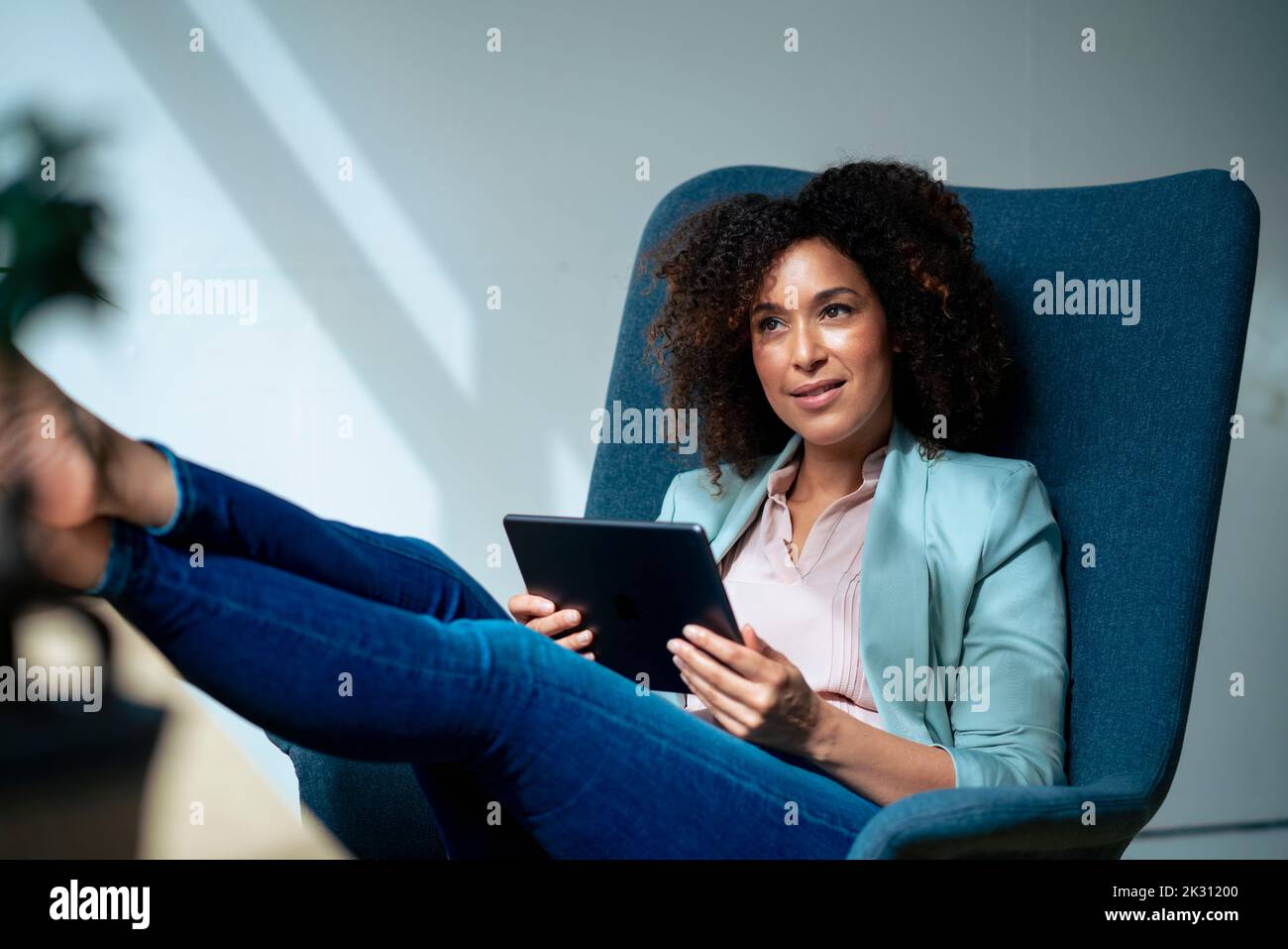 Durchdachte Geschäftsfrau mit Tablet-Computer am Arbeitsplatz Stockfoto