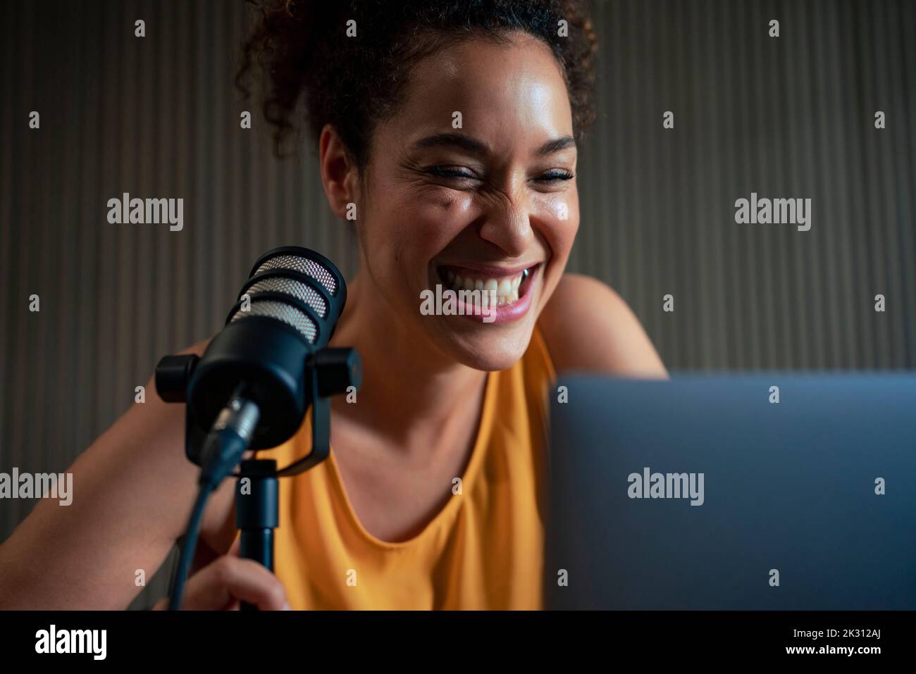 Fröhlicher Radiomoderator mit Mikrofon-Podcasting im Studio Stockfoto