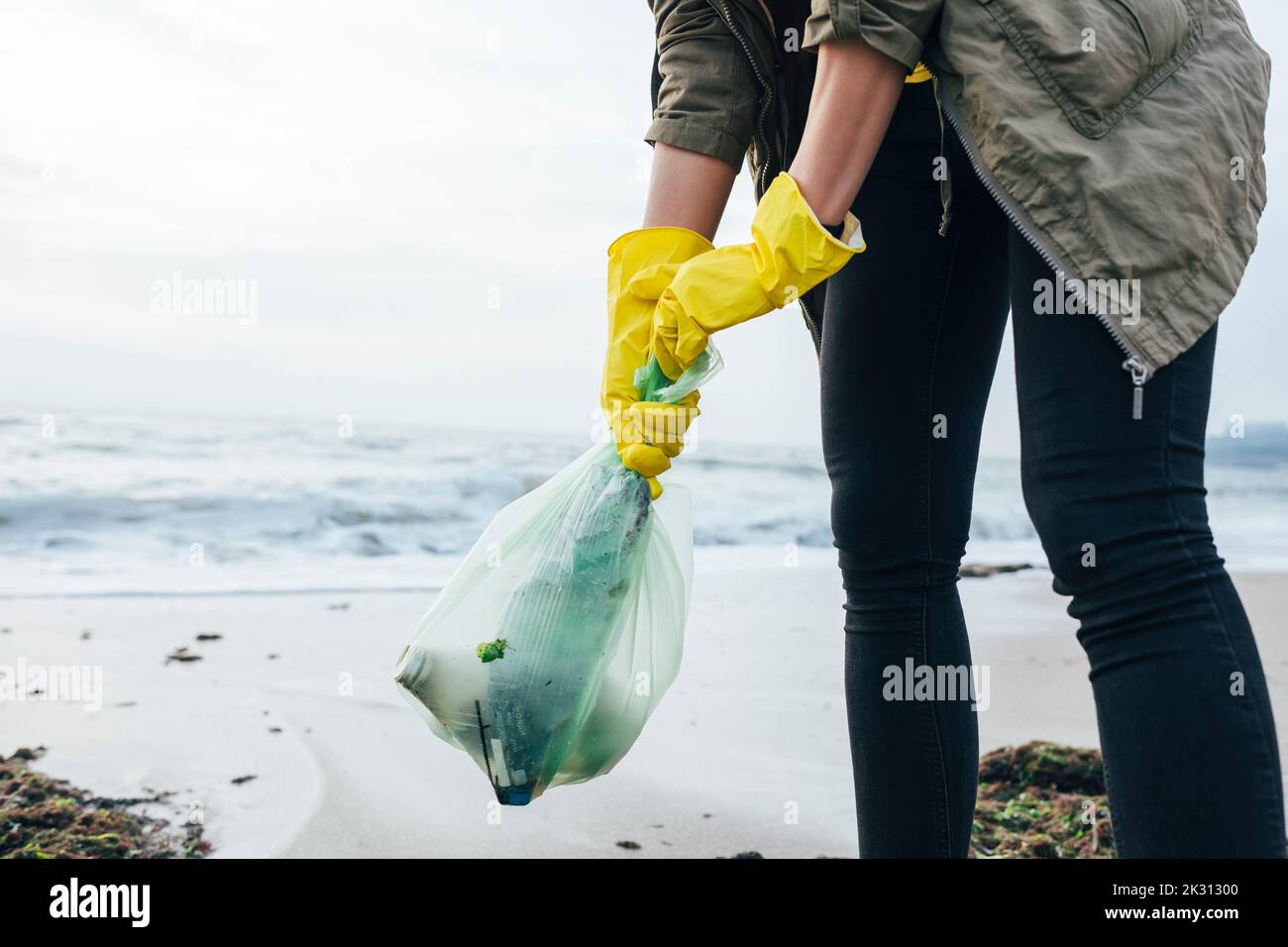 Frau sammelt Plastikmüll am Strand Stockfoto