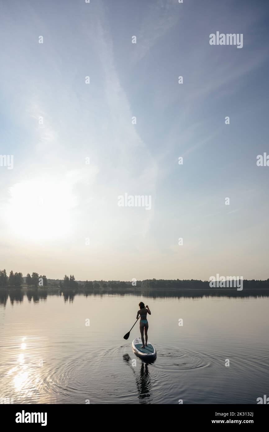Frau macht Stand-up-Paddleboarding im See Stockfoto