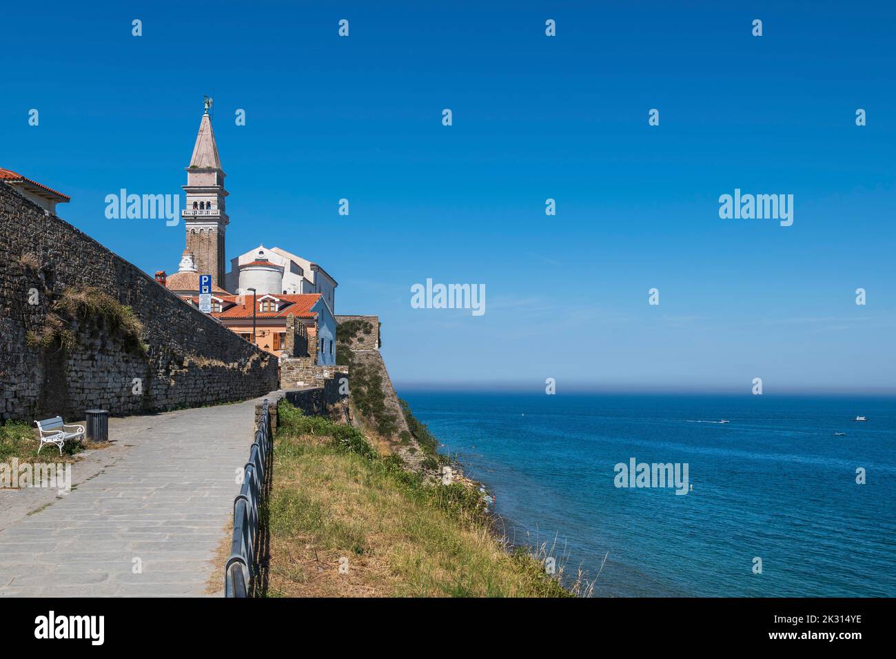 Slowenien, Piran, Strandpromenade mit Glockenturm der St. Georg Kirche im Hintergrund Stockfoto