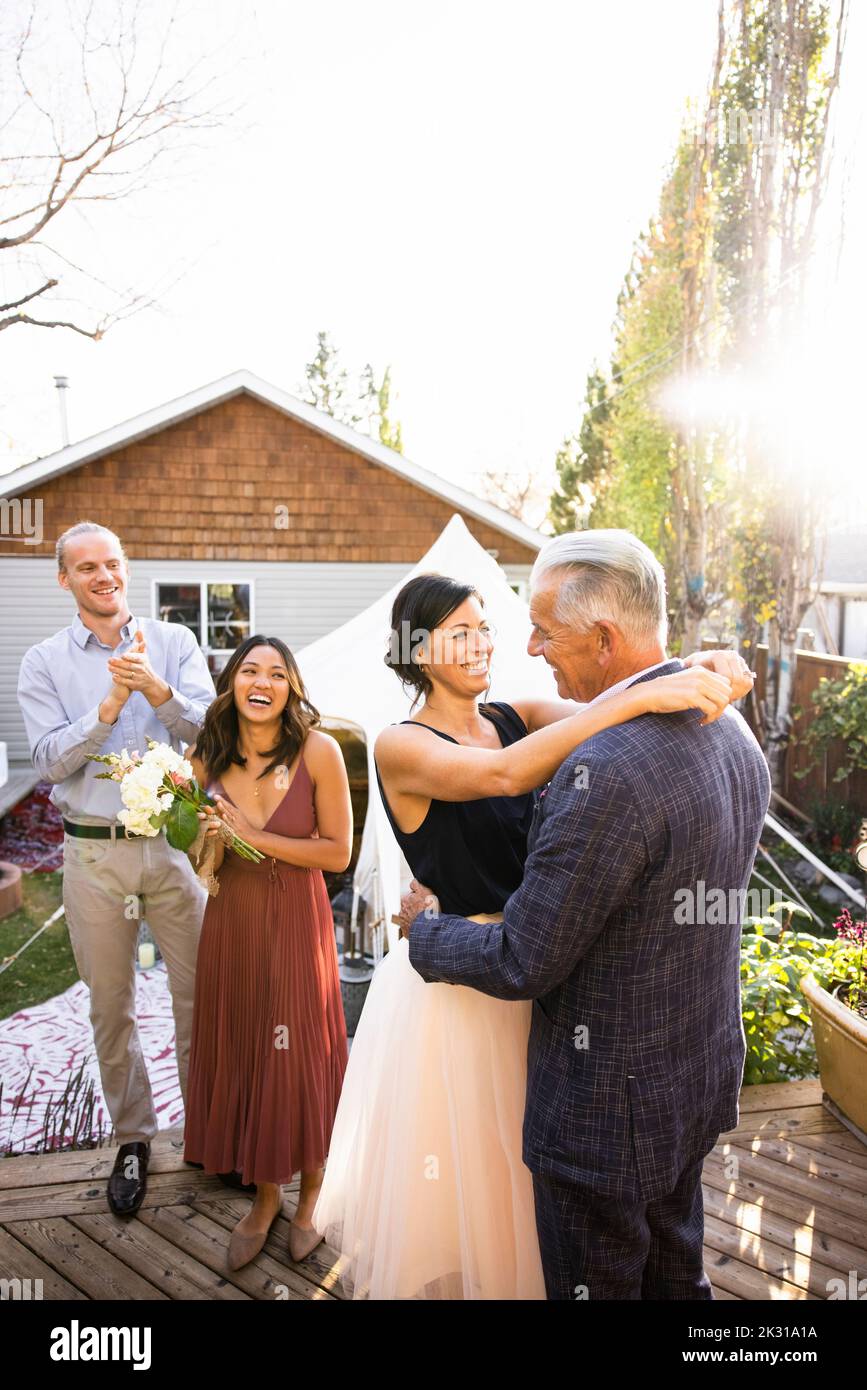 Das ältere Brautpaar umarmt sich bei der Hochzeitsfeier im Garten Stockfoto