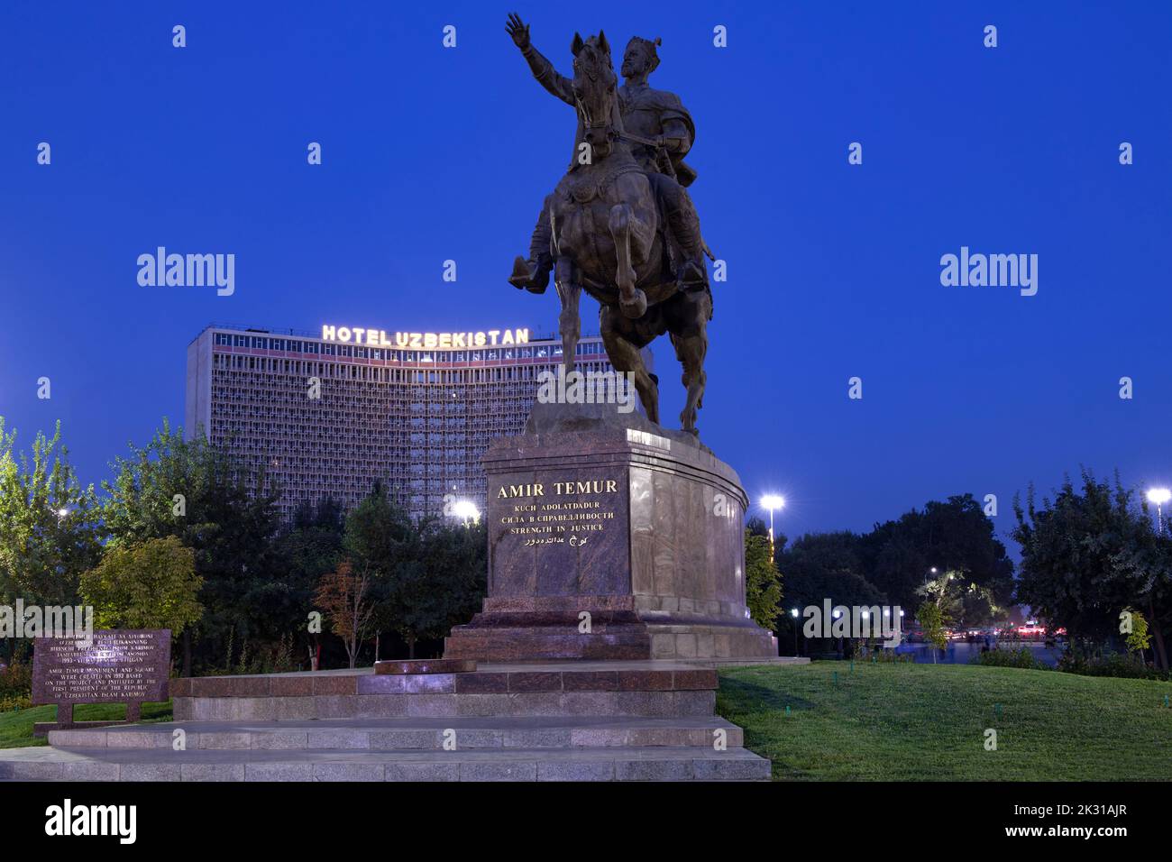 TASCHKENT, USBEKISTAN - 15. SEPTEMBER 2022: Denkmal für Amir Temur (Tamerlane) vor dem Hintergrund des Hotels Usbekistan am Abend des twi Stockfoto