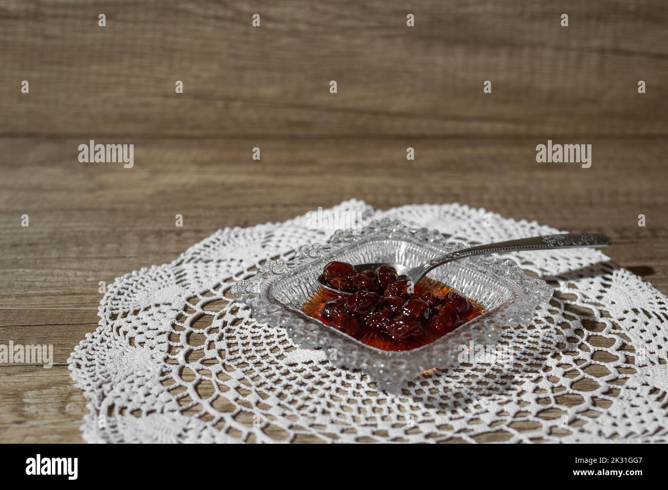 Sour Cherry Löffel süß serviert, die traditionelle Art, durch den Löffel auf einem kleinen Teller Stockfoto