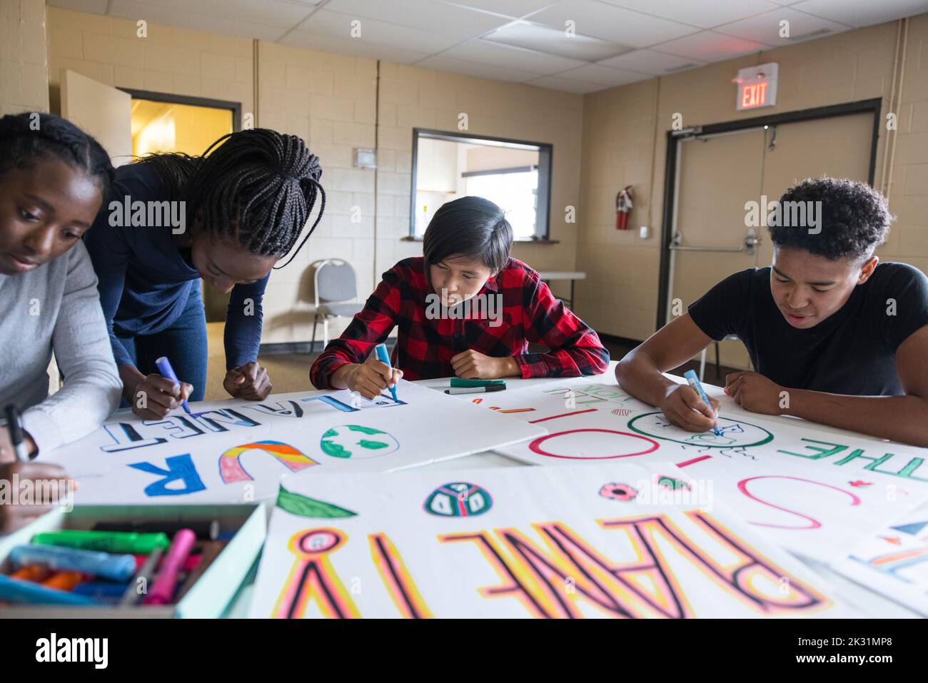 Teen Umweltaktivisten zeichnen Plakate im Gemeindezentrum Stockfoto