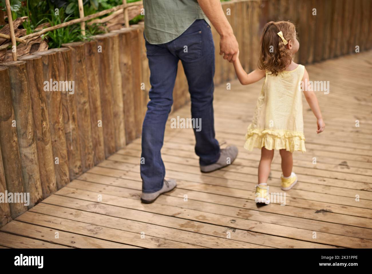 Das Aquarium ist eine große Touristenattraktion. Rückansicht eines Vaters und einer Tochter, die bei einem Ausflug Hand in Hand gehen. Stockfoto