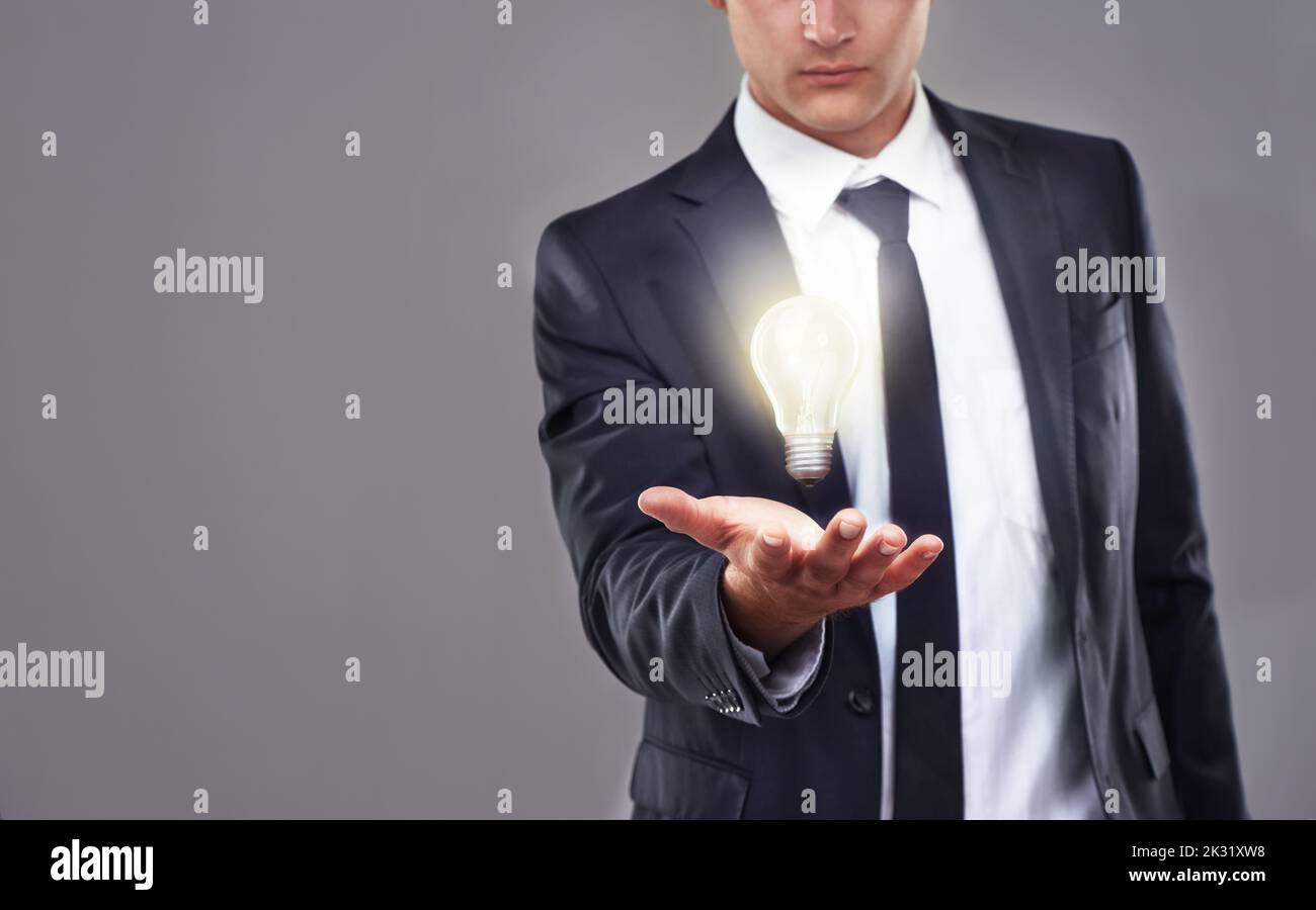 Den Weg zu nachhaltigen Geschäftspraktiken zu finden. Ein Geschäftsmann mit einer glühenden Glühbirne. Stockfoto