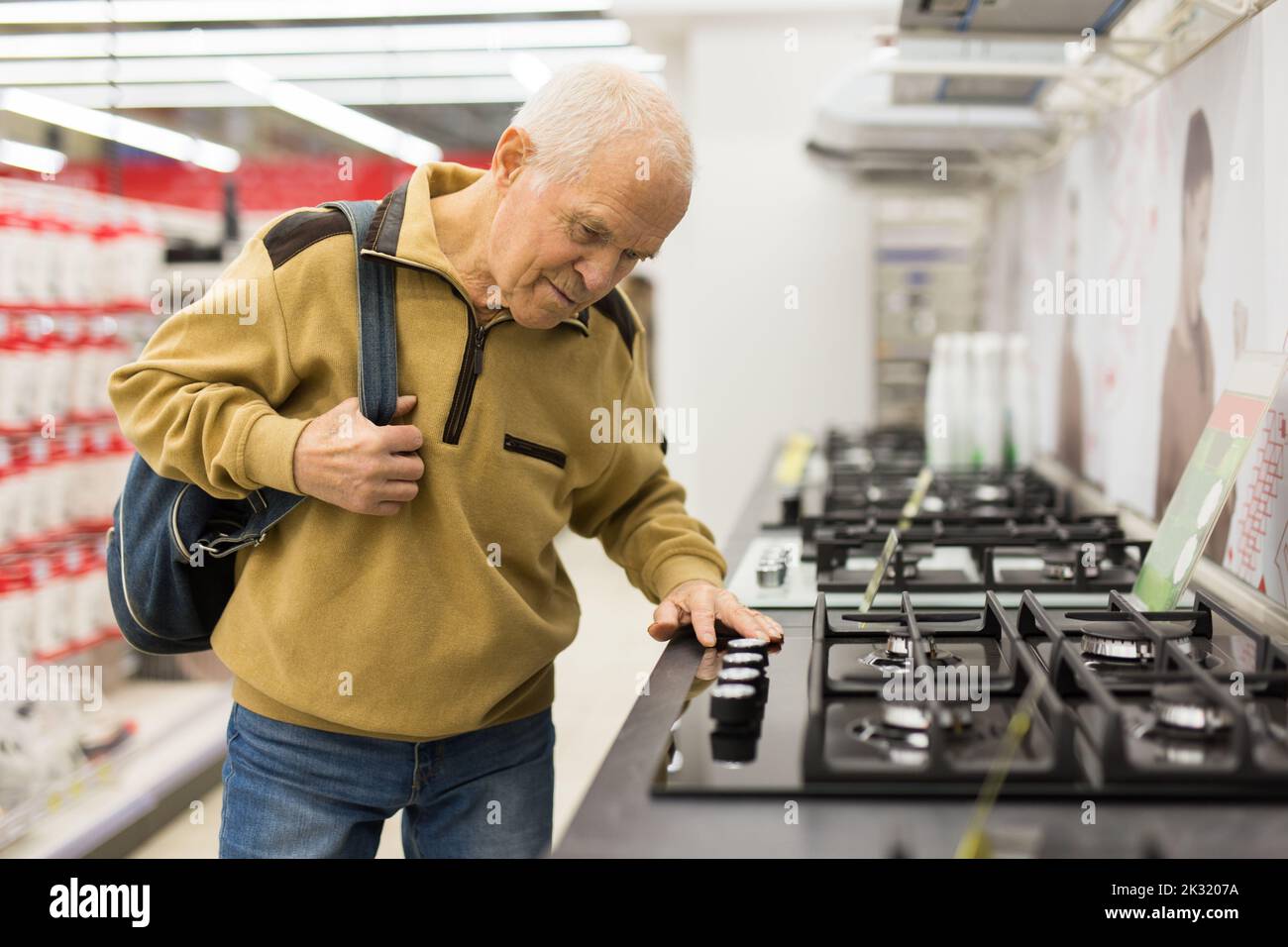 senor Mann Rentner Kauf Küchenherd im Ausstellungsraum des Elektrogeräteladens Stockfoto