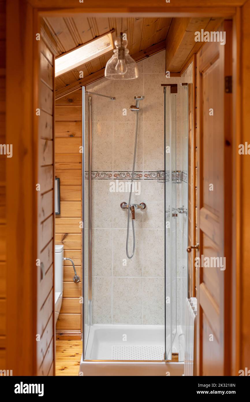 Innenausstattung des Badezimmers im Landhausstil. Duschkabine mit Holzwänden Stockfoto