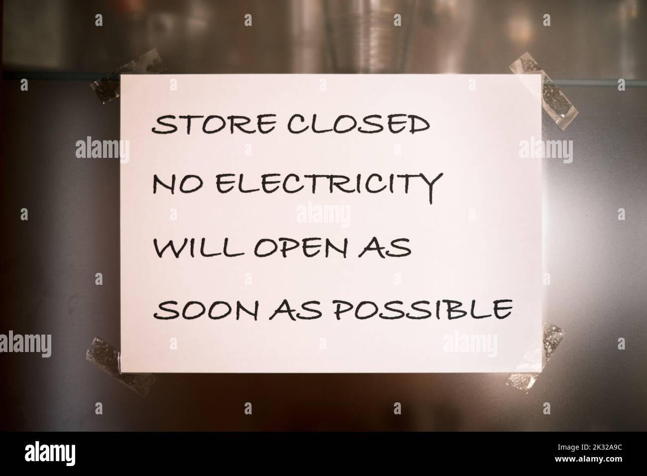 Nahaufnahme eines Hinweises auf einem Schaufenster mit der Aufschrift: Geschäft geschlossen kein Strom öffnet So bald wie möglich. Stockfoto