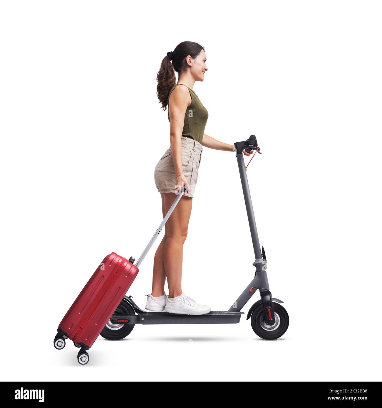 Junge Frau, die eine Trolley-Tasche trägt und einen schnellen Elektroroller fährt, ein Konzept für nachhaltige Mobilität, isoliert auf weißem Hintergrund Stockfoto