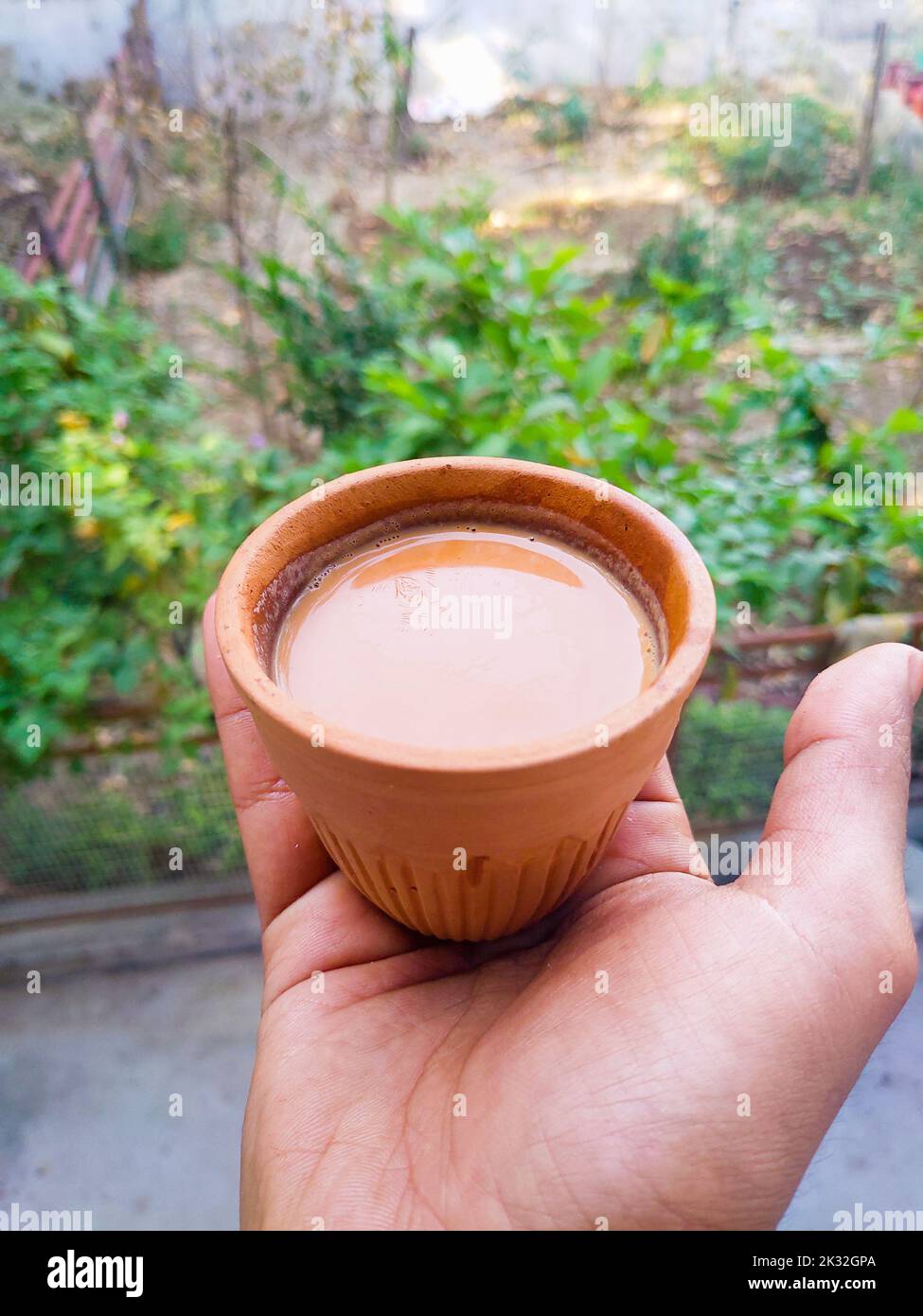 Handgehaltener heißer indischer gewürzter Tee, serviert in einem traditionellen Tonkessel namens Kulhad. Uttarakhand, Indien. Stockfoto