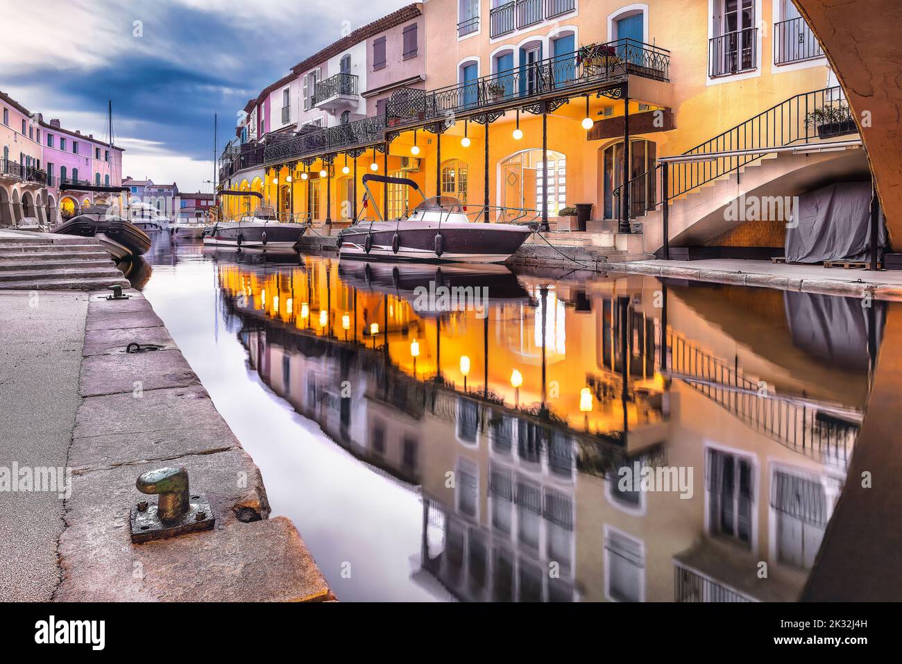 Malerischer Blick auf Port Grimaud bei Nacht im Herbst, der das Kanalwasser vor dem dramatischen Herbsthimmel reflektiert Stockfoto