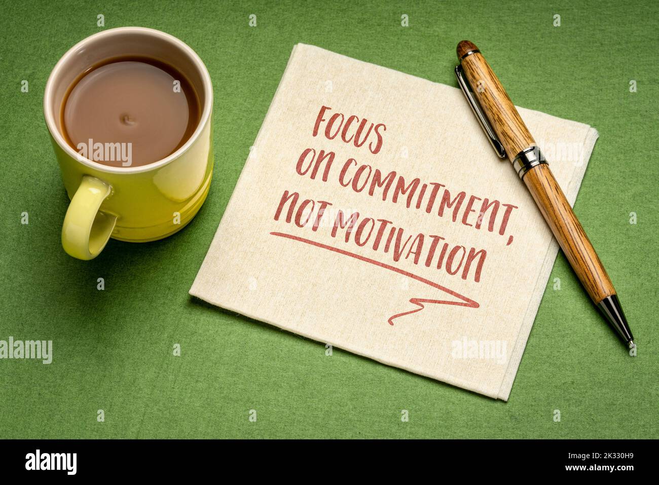 Konzentrieren Sie sich auf Engagement, nicht auf Motivation – inspirierende Notiz auf einer Serviette mit einer Tasse Kaffee, persönliches Entwicklungskonzept Stockfoto