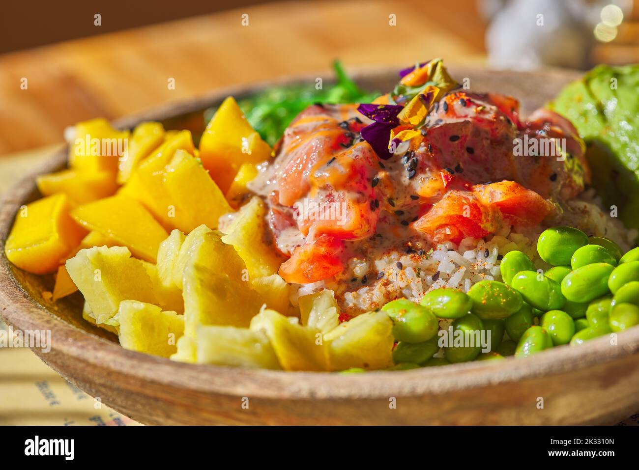 Thunfisch und Lachs Poke Bowl Roher Fischsalat Asiatische Speisen mit Bohnen, Edamame, Quinoa, Avocado, Ananas, Gurke und Salat in einer Schüssel - Nahaufnahme Stockfoto