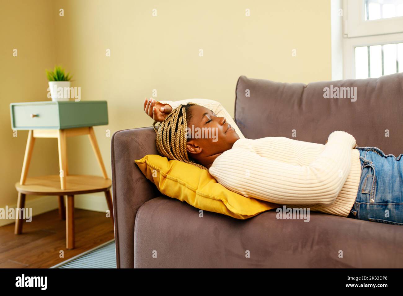 Müde lateinische hispanische Frau, die tagsüber ein Nickerchen auf dem Sofa machte Stockfoto