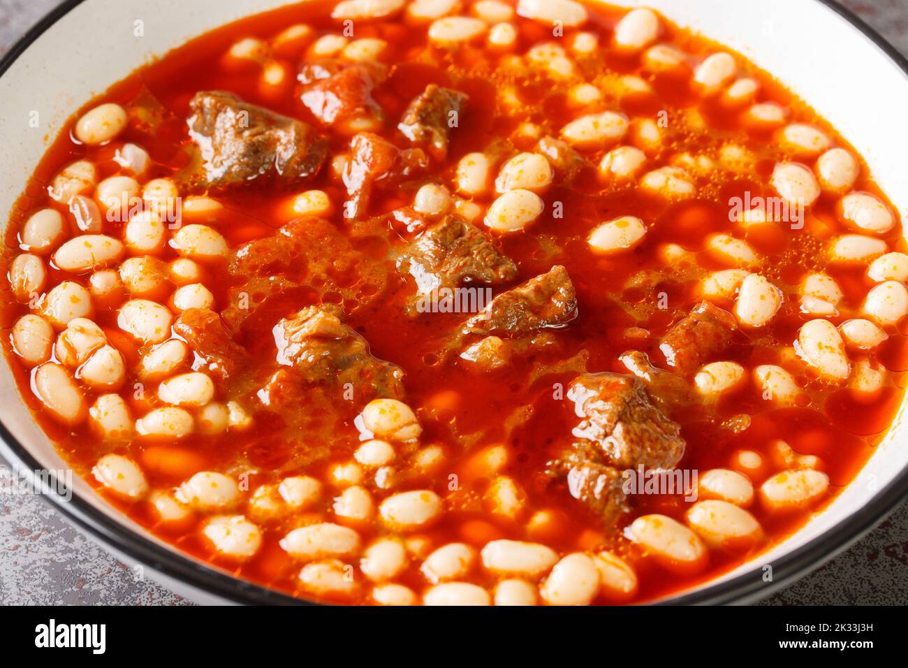 Scharfe türkische Küche Kuru Fasulye aus Bohnen mit Lamm in Tomatensauce close-up in einer Schüssel auf dem Tisch. Horizontal Stockfoto