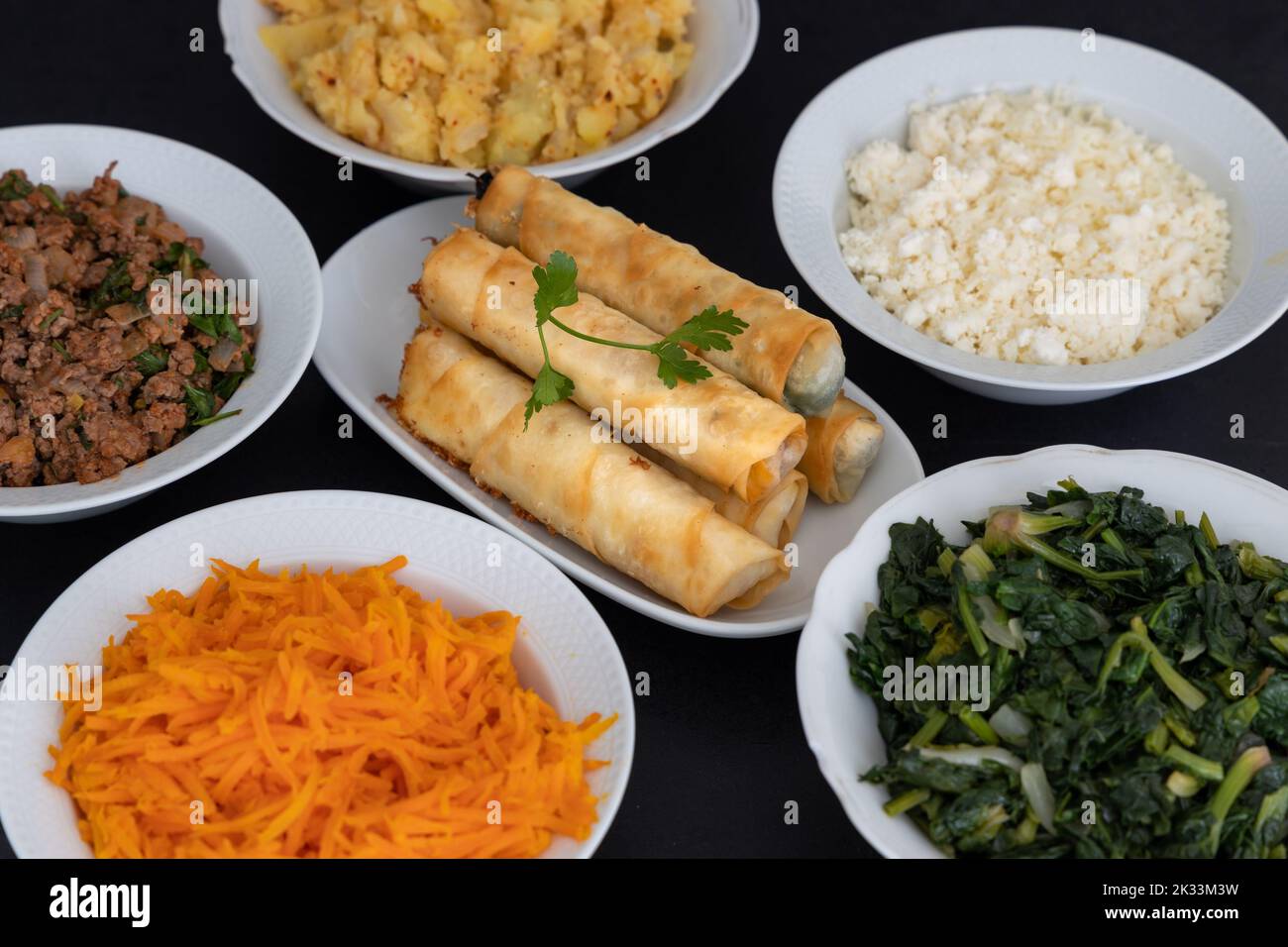 Türkische Rollen In Zigarrenform. Traditionelle Borek, Burek, gekochte, gegrillte frische Frühlingsrollen Essen auf schwarzem Hintergrund. Kopierbereich, Draufsicht. Stockfoto