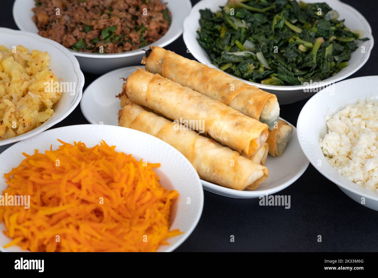 Türkische Rollen In Zigarrenform. Traditionelle Borek, Burek, gekochte, gegrillte frische Frühlingsrollen Essen auf schwarzem Hintergrund. Kopierbereich, Draufsicht. Stockfoto