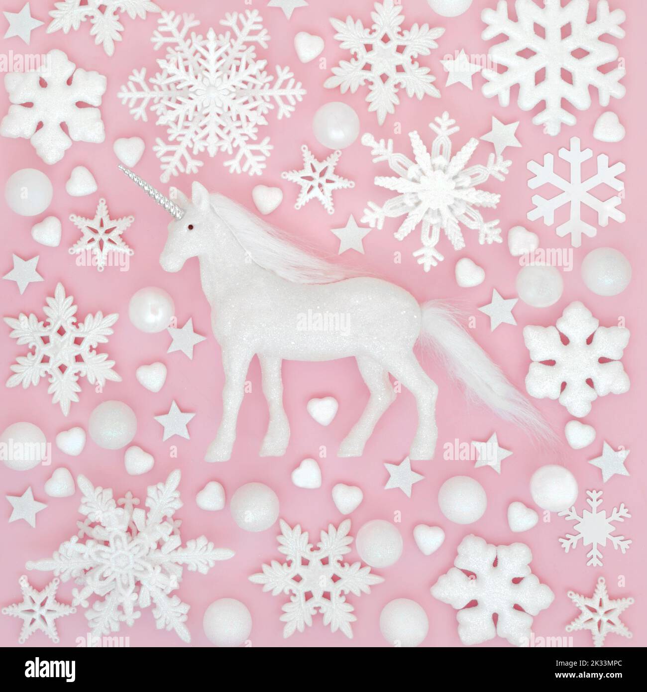 Mythisches Weihnachts-Einhorn, Schneeflocke und Baumkugeln. Fantasy Nordpol rosa Hintergrund-Design für Winter, Weihnachten und Neujahr Weihnachtszeit. Stockfoto