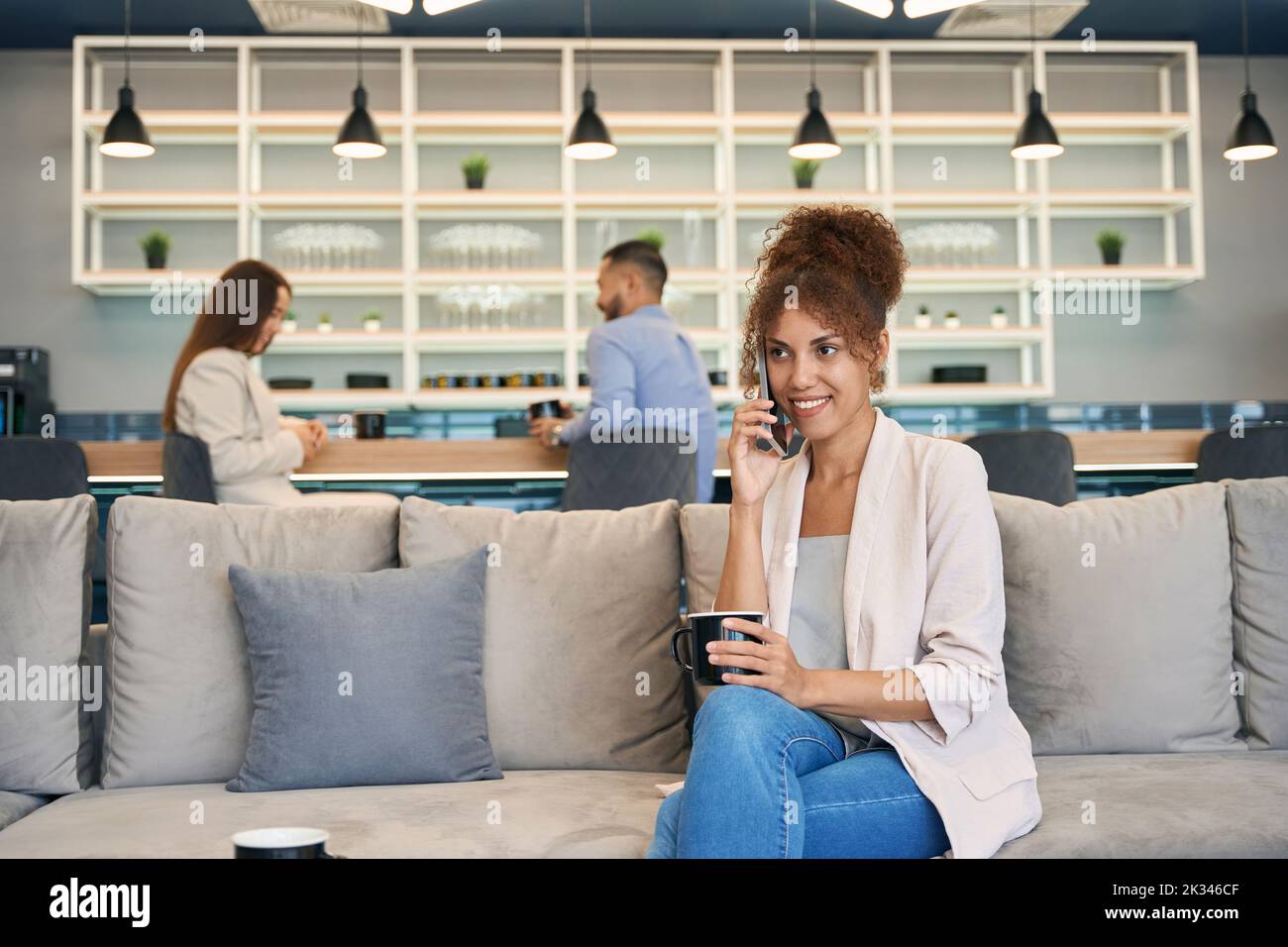 Frau, die während der Kaffeepause ein Telefongespräch führt Stockfoto