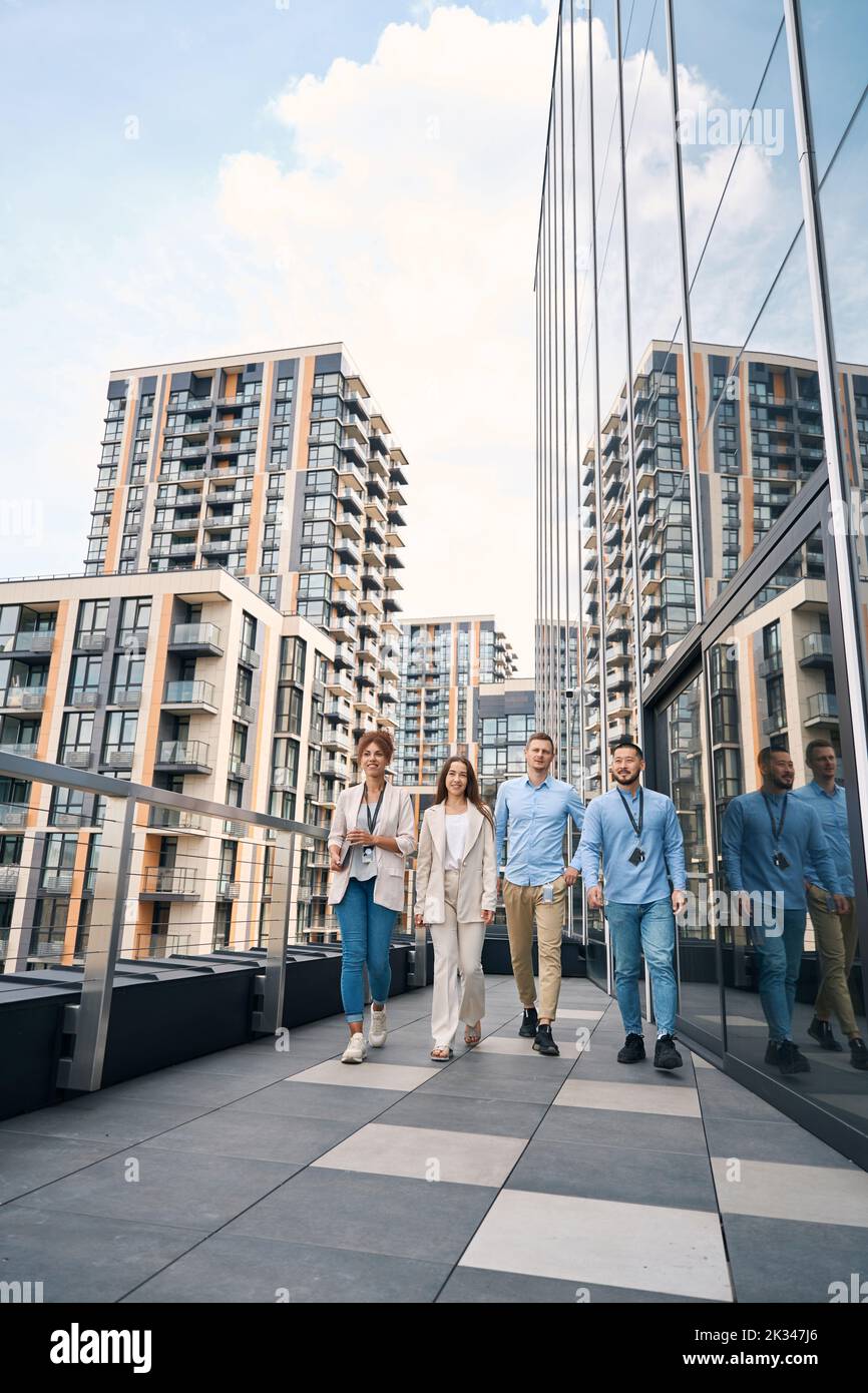 Ein multiethnisches Team von Firmenmitarbeitern, die während der Mittagspause spazieren gehen Stockfoto