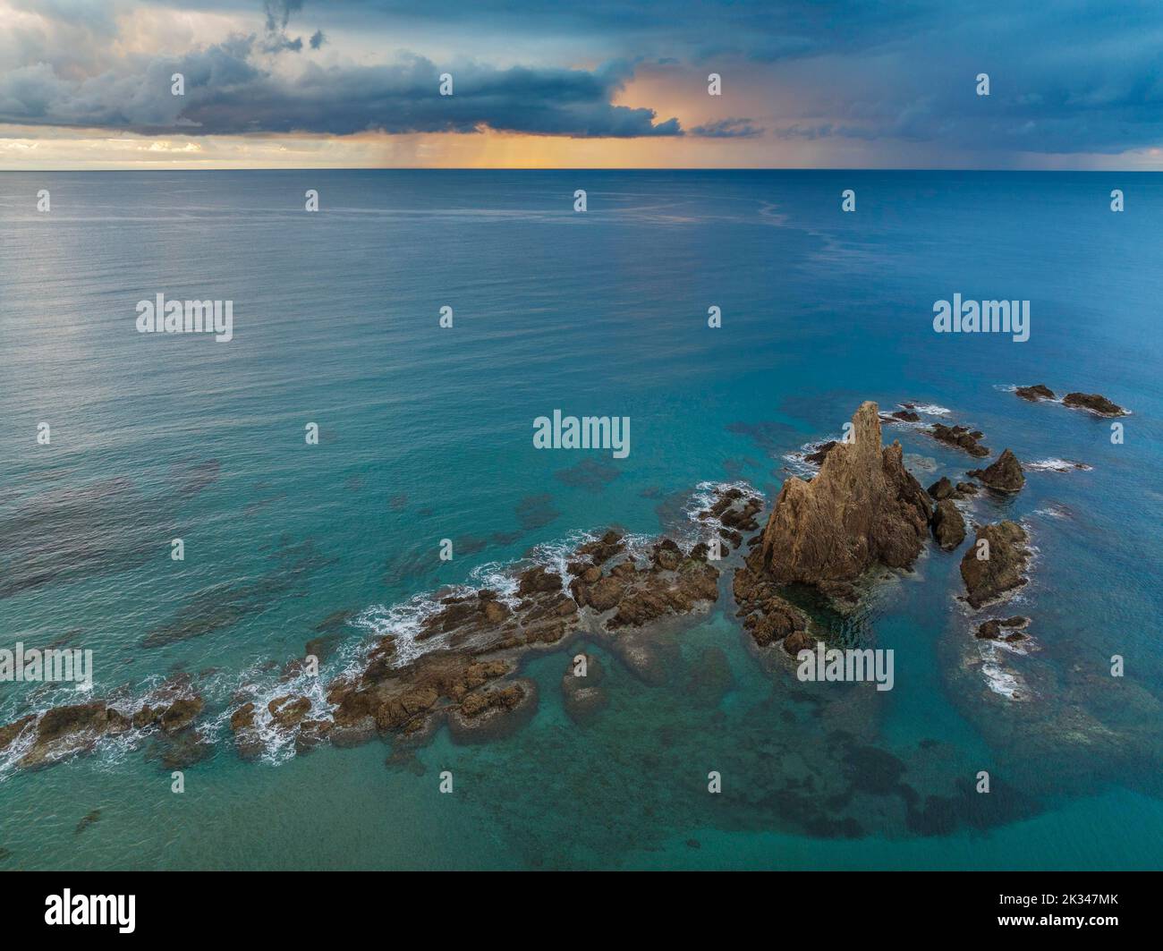 Das Riff Arrecife de las Sirenas im Naturschutzgebiet Cabo de Gata-Nijar, bei Sonnenaufgang mit starken Schauern in der Ferne, Luftaufnahme, Drohnenschuss Stockfoto