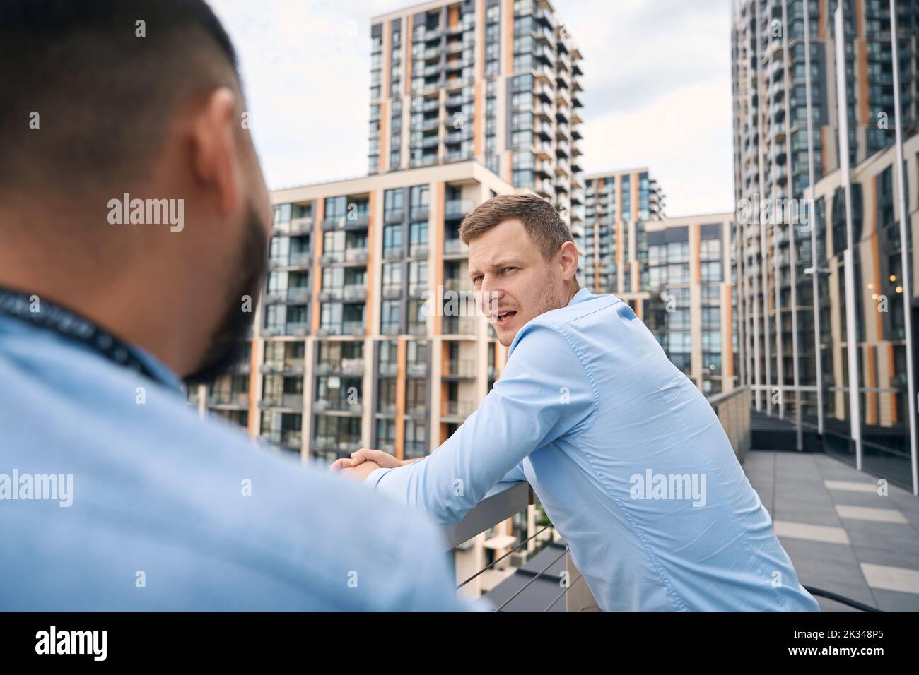 Büroangestellter im Freien, der mit seinem Kollegen spricht Stockfoto