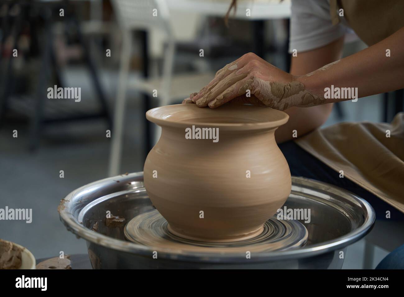 Potter arbeitet mit einer Tonvase auf einem Töpferrad Stockfoto