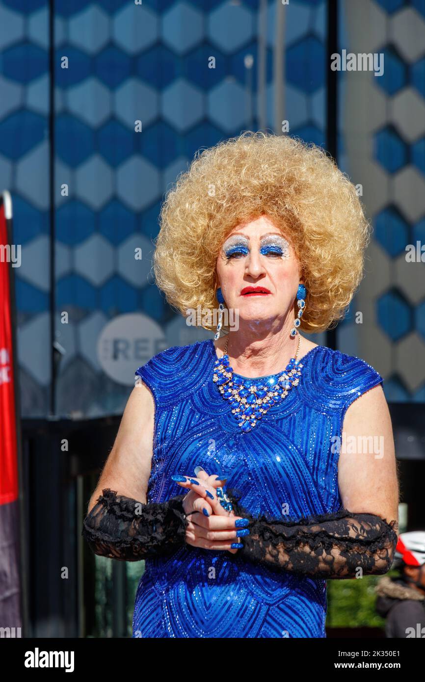 Trans-Frau in Drag trägt blonde Perücke und funkelndes blaues Kleid bei der Gay Pride Parade 2022 im zentrum von birmingham, großbritannien, 24.. september Stockfoto