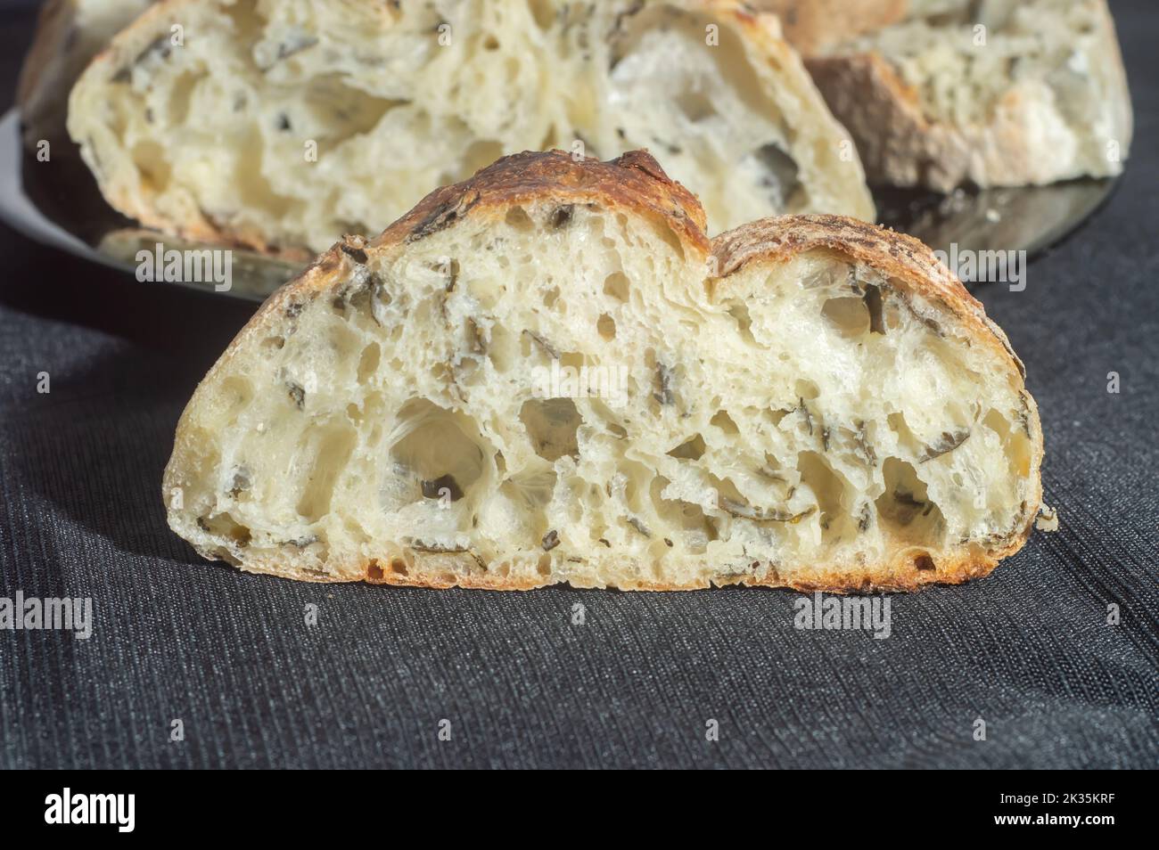 Handgemachtes Brot mit natürlicher Gärung auf einer schwarzen Schale. Stockfoto